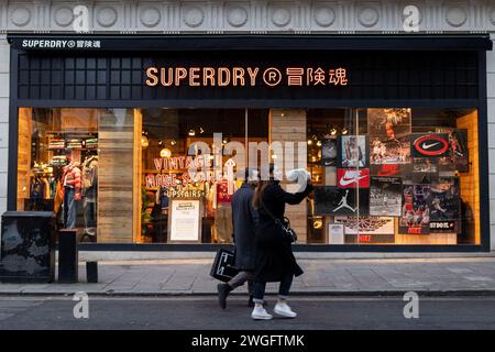 Londra, Regno Unito. 4 febbraio 2024. Gli amanti dello shopping passeranno davanti al negozio principale di Superdry in Bond Street a Londra. Superdry è in fase di ricostruzione della sua struttura aziendale dopo l'avviso di profitto a causa del calo delle vendite. La ricostruzione può portare a significative chiusure di punti vendita e tagli al lavoro. Credito: SOPA Images Limited/Alamy Live News Foto Stock