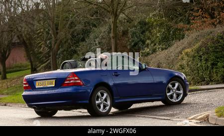 Milton Keynes, Regno Unito - 4 febbraio 2024: 2000 Mercedes Benz SLK blu, auto d'epoca open top, che guida su una strada inglese. Foto Stock