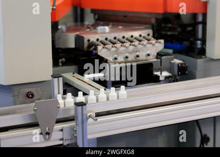 Produzione di piccole bottiglie in plastica con pressa rotativa per soffiaggio. Messa a fuoco selettiva. Foto Stock