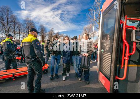 Gli attivisti della ribellione dell'estinzione sono scortati a un autobus in attesa, durante la manifestazione. La polizia ha rimosso 1.000 attivisti per il clima dalla A12 a l'Aia e li ha trasferiti allo stadio di calcio ADO a l'Aia, dove sono stati rilasciati. L'autostrada è stata bloccata in entrambe le direzioni da alcuni attivisti per il clima dalla ribellione dell'estinzione dalle 13:00, anche se erano presenti due canoni d'acqua, non sono stati utilizzati. Fu il primo blocco dell'A12 in quattro mesi. L'anno scorso, Extinction Rebellion ha bloccato l'A12 diverse dozzine di volte. Le loro azioni sono state sospese il 10 ottobre. La Casa dei Repres Foto Stock