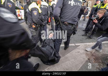 Gli attivisti della ribellione dell'estinzione sono scortati a un autobus in attesa, durante la manifestazione. La polizia ha rimosso 1.000 attivisti per il clima dalla A12 a l'Aia e li ha trasferiti allo stadio di calcio ADO a l'Aia, dove sono stati rilasciati. L'autostrada è stata bloccata in entrambe le direzioni da alcuni attivisti per il clima dalla ribellione dell'estinzione dalle 13:00, anche se erano presenti due canoni d'acqua, non sono stati utilizzati. Fu il primo blocco dell'A12 in quattro mesi. L'anno scorso, Extinction Rebellion ha bloccato l'A12 diverse dozzine di volte. Le loro azioni sono state sospese il 10 ottobre. La Casa dei Repres Foto Stock