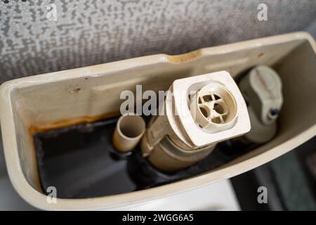 Cisterna del bagno con acqua scura, primo piano. Pulsante scarico WC Foto Stock