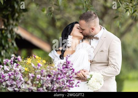 Gli sposi novelli si baciano dopo la cerimonia di nozze. Foto Stock