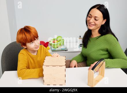 Specialista dello sviluppo infantile donna che lavora con bambini con disturbo dello spettro autistico. Terapia basata sul gioco Foto Stock