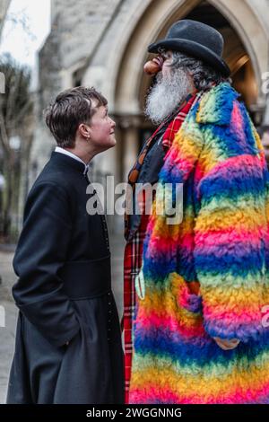 Il clero e il clown si affrontano in allegria all'evento annuale Joseph Grimaldi. Foto Stock