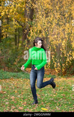Donna che corre nella foresta per paura Foto Stock