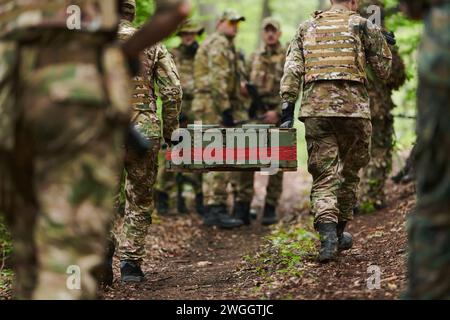 L'unità militare d'élite, vestita di mimetismo, trasporta una cassa di munizioni attraverso la fitta foresta, incarnando la prontezza strategica e la precisione Foto Stock