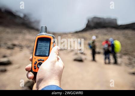 Dispositivo GPS in mano all'escursionista sulla strada per il monte Kilimanjaro, Tanzania Foto Stock