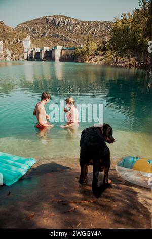 Gli amici si rinfrescano in un bel lago durante una calda giornata estiva Foto Stock