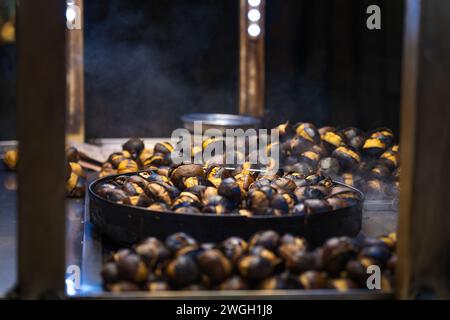 Primo piano di castagne arrostite all'aperto la sera, Istanbul, Turchia. Cibo di strada Foto Stock