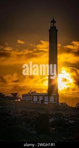 Faro Maspalomas Gran Canaria al mattino presto, cielo dorato, tramonto dietro le nuvole Foto Stock