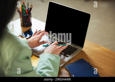 Concentratevi sulle mani femminili che digitano sul laptop, pianificano le vacanze, cercano tour, scelgono hotel, sistemazioni e servizi turistici Foto Stock