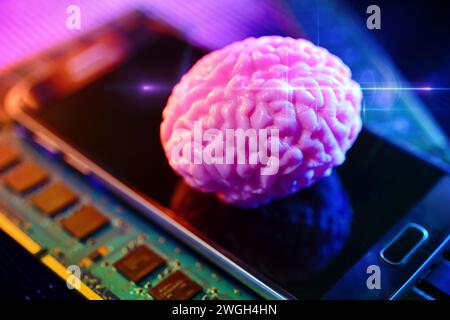 Cervello su smartphone con schede per computer, neurotecnologia fotografica simbolica Foto Stock