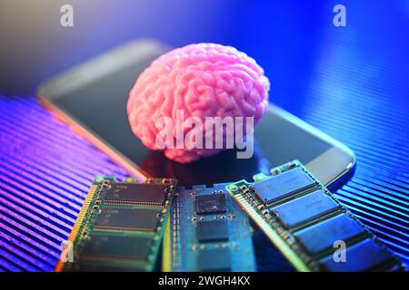 Cervello su smartphone con schede per computer, neurotecnologia fotografica simbolica Foto Stock