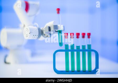 Un robot sperimentale in un laboratorio scientifico manipola le provette con una sostanza chimica Foto Stock