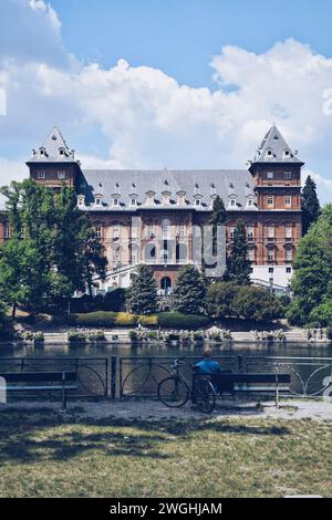 Uomo seduto sulle rive del po a Torino, Italia. Il 9 maggio 2022 Foto Stock