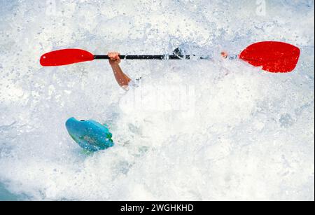 Kayak quasi sotto un'onda dell'Isar al Wittelsbacherbrücke, Monaco, Germania Foto Stock