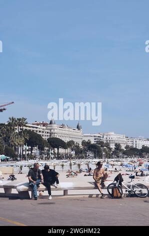 Persone sedute sul lungomare di Cannes in Francia, il 16 aprile 2019 Foto Stock