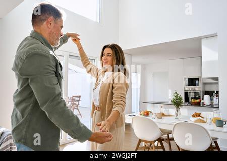 Romantica felice vecchia coppia matura in amore ballando nella cucina di casa. Foto Stock