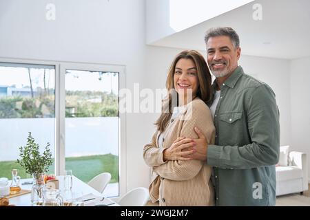 Ritratto di una coppia felice sorridente e matura proprietari di immobili in piedi a casa. Foto Stock