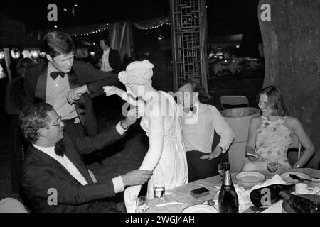 Ricco gruppo di uomini della classe media che si aggirano con una statua, utilizzata come decorazione per la fine annuale dell'estate Berkeley Square Ball a Londra. Westminster, Londra, Inghilterra settembre 1981 1980 UK HOMER SYKES Foto Stock