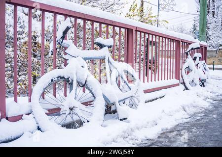 Bicicletta catturata durante una tempesta di neve serale... Neve innevata di torce di neve Foto Stock