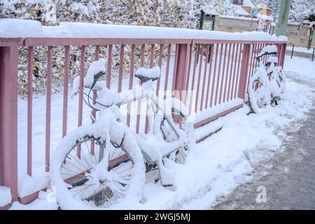 Bicicletta catturata durante una tempesta di neve serale... Neve innevata di torce di neve Foto Stock