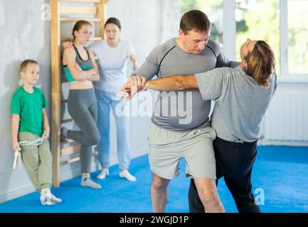 L'uomo in palestra esegue elementi di base del sistema di autodifesa krav maga. Foto Stock