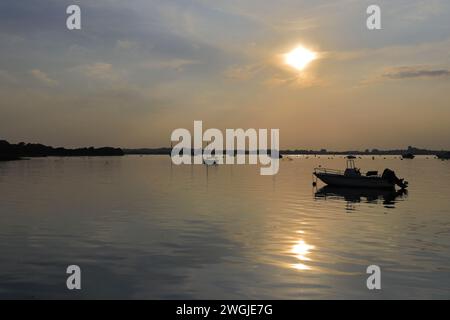 Tramonto sulle barche a Mudeford Quay, Christchurch Harbour, Dorset; Inghilterra, Regno Unito Foto Stock