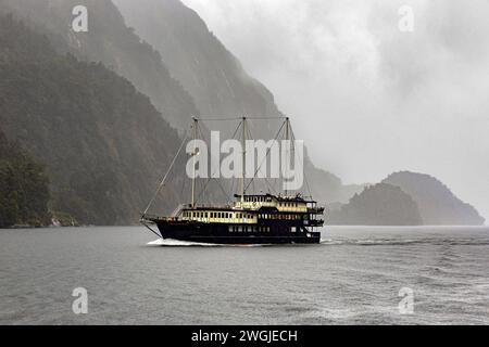 Nave da crociera turistica in una giornata di pioggia a Doubtful Sound / Patea, Fiordland / te Rua-o-te-Moko, nuova Zelanda / Aotearoa, South Island /te Waipoun Foto Stock