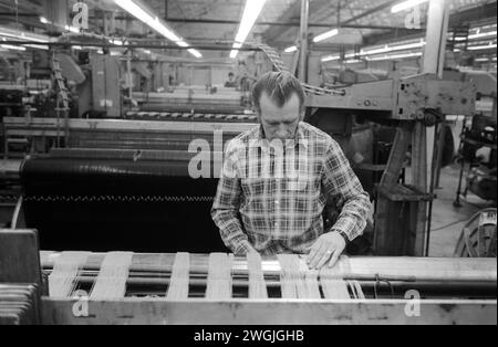 Fabbrica vittoriana, uomo che lavora nell'industria tessile Salts Mill. Lavoro nell'area di produzione degli anni '1980 del Regno Unito. Fabbrica di tessuti di cotone Saltaire, vicino Bradford, West Yorkshire Inghilterra 1981. HOMER SYKES Foto Stock