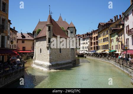 Annecy, Francia - 14 giugno 2021: Storico castello medievale (le Palais de Ille) nel mezzo del canale di Thiou Foto Stock