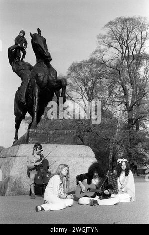 Flower Power 1970s hippies Regno Unito. Kensington Gardens che fa musica sotto la statua dell'energia fisica, di George Frederick Watts. Kensington, Londra. 1971 Inghilterra HOMER SYKES Foto Stock