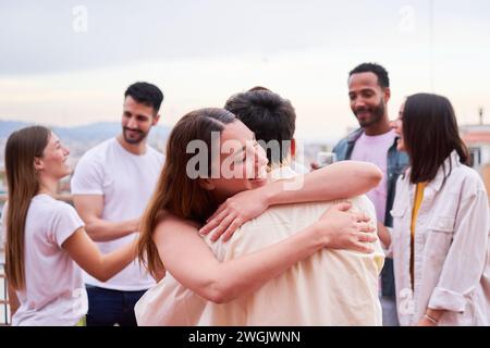 Due amici che si abbracciano all'aperto durante una riunione sociale. Foto Stock
