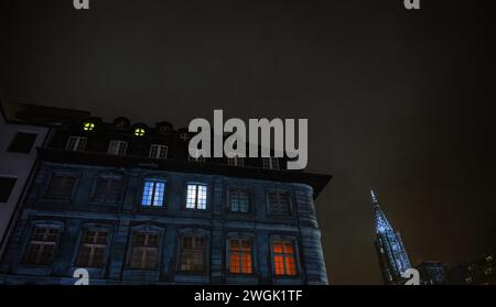 L'ampia prospettiva ultra-grandangolare cattura la grandiosità di un edificio immobiliare di lusso con una finestra elegantemente illuminata, armoniosamente incorniciata dalla maestosa Cattedrale di Notre-Dame nel cuore di Strasburgo, sotto la vasta tela di un cielo serale azzurro Foto Stock