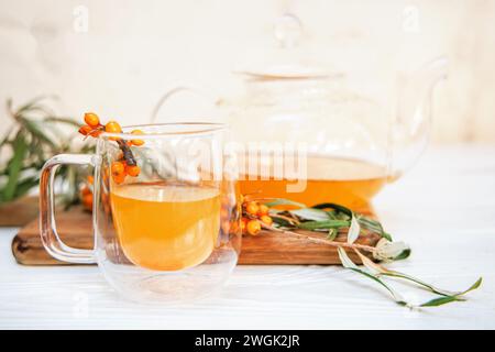 tazza di vetro trasparente ripiena di tè aromatico di spinaci marini, insieme a una teiera trasparente. tè di pesce ricco di vitamine, un rimedio naturale per il benessere Foto Stock