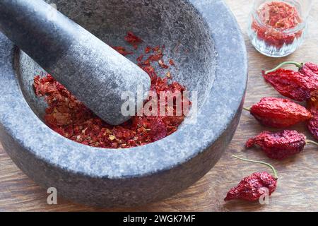 Peperoni caldi secchi Jolokia Bhut in un mortaio Foto Stock