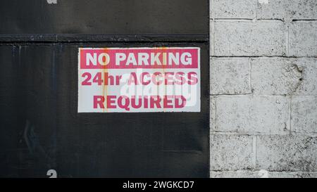 Nessuna segnaletica di parcheggio sulle unità industriali a causa dei requisiti di accesso per le unità industriali. Lettere rosse su sfondo bianco, Foto Stock