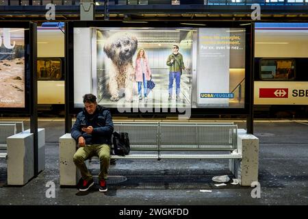 Ginevra città in Svizzera stazione ferroviaria Gare de Genève passeggero seduto su una panchina Foto Stock