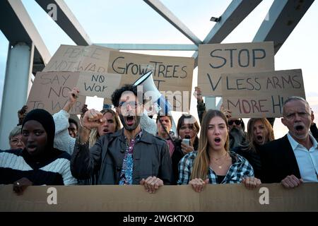 Gruppi di attivisti di età diverse si sono riuniti urlando durante la manifestazione. Persone che protestano all'aperto. Foto Stock