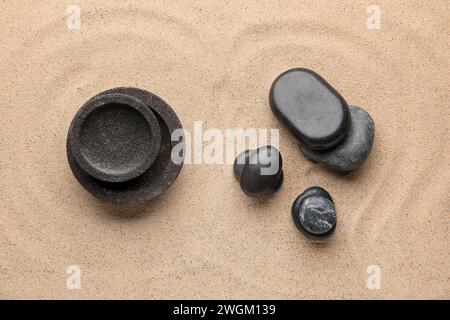 Pietre e ciotole del centro benessere sullo sfondo di sabbia. Concetto Zen Foto Stock