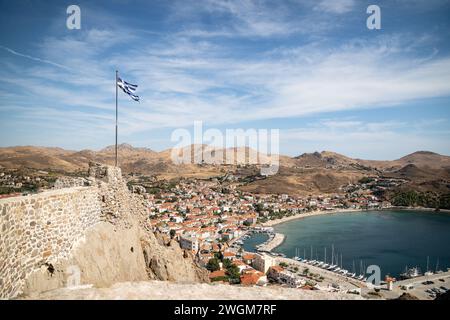 La grandezza di Myrina: Una vista accattivante di un castello e della bandiera greca che si innalza sopra la storica capitale di Lemnos, in Grecia. Foto Stock