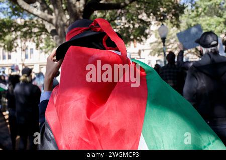 Austin, Texas, Stati Uniti. 4 febbraio 2024. Un manifestante che indossa una bandiera palestinese cammina tra la folla presso il Campidoglio dello Stato del Texas ad Austin Texas domenica 3 febbraio 2024 durante il Texas United Against Genocide. La gente si è riunita per chiedere un cessate il fuoco immediato. Israele ha sottoposto Gaza a centoventi giorni di bombardamenti, che finora hanno ucciso ventisettemila civili. (Credit Image: © Jaime Carrero/ZUMA Press Wire) SOLO PER USO EDITORIALE! Non per USO commerciale! Foto Stock