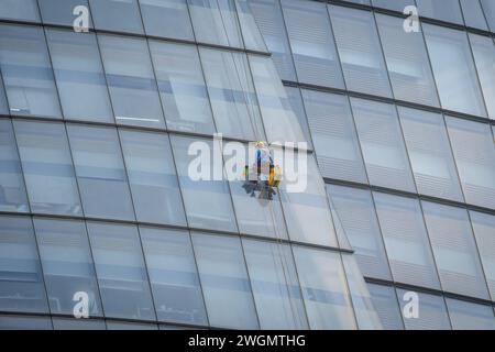 22 gennaio 2024: I lavoratori puliscono il vetro su edifici alti a ho chi Minh City, Vietnam Foto Stock