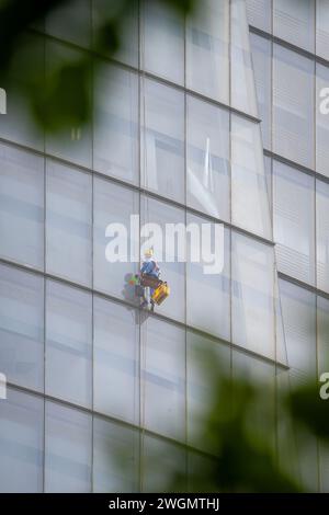 22 gennaio 2024: I lavoratori puliscono il vetro su edifici alti a ho chi Minh City, Vietnam Foto Stock