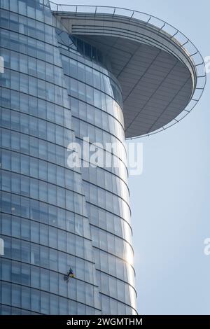 22 gennaio 2024: I lavoratori puliscono il vetro su edifici alti a ho chi Minh City, Vietnam Foto Stock