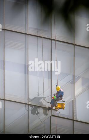 22 gennaio 2024: I lavoratori puliscono il vetro su edifici alti a ho chi Minh City, Vietnam Foto Stock