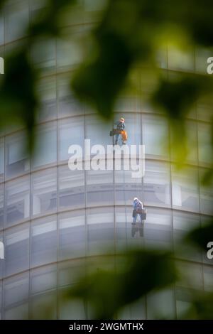 22 gennaio 2024: I lavoratori puliscono il vetro su edifici alti a ho chi Minh City, Vietnam Foto Stock