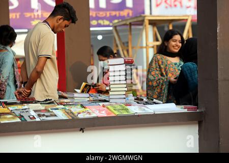 Dhaka, Wari, Bangladesh. 5 febbraio 2024. I visitatori leggono libri alla fiera nazionale del libro chiamata Ekushey Boi Mela a Dacca. Ogni anno, la Bangla Academy organizza la fiera nazionale del libro nell'area dell'Università di Dhaka. Questa fiera del libro è la più grande del Bangladesh e si svolge per tutto il mese di febbraio. Dacca, Bangladesh, 6 febbraio 2024. (Credit Image: © Habibur Rahman/ZUMA Press Wire) SOLO PER USO EDITORIALE! Non per USO commerciale! Foto Stock