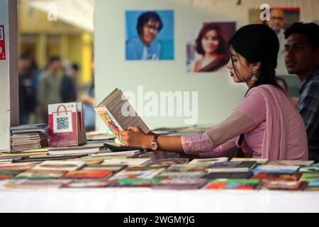 Dacca, Bangladesh. 6 febbraio 2024. I visitatori leggono libri alla fiera nazionale del libro chiamata Ekushey Boi Mela a Dacca. Ogni anno, la Bangla Academy organizza la fiera nazionale del libro nell'area dell'Università di Dhaka. Questa fiera del libro è la più grande del Bangladesh e si svolge per tutto il mese di febbraio. Dacca, Bangladesh, 6 febbraio 2024. Foto di Habibur Rahman/ABACAPRESS.COM credito: Abaca Press/Alamy Live News Foto Stock